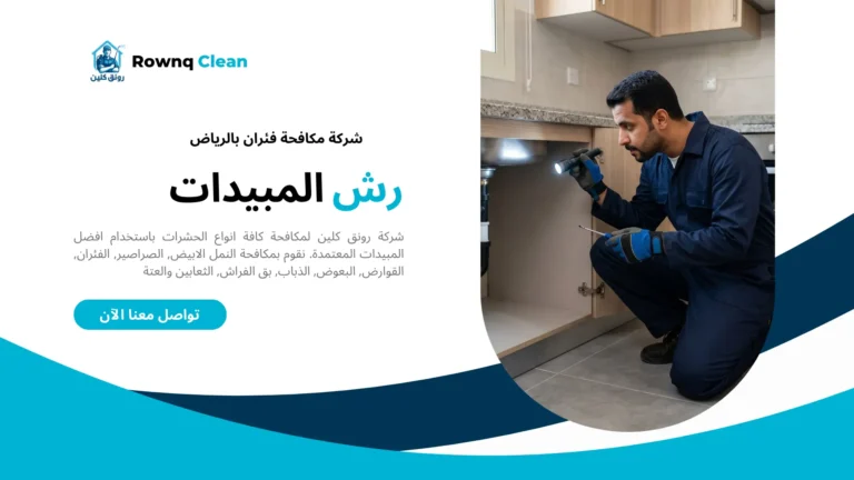 فني يفحص الفجوات حول أنابيب المطبخ بمصباح يدوي.